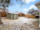 Fenced backyard featuring a storage shed, small retaining wall, and mature trees at 3293 S Fairplay St, Aurora, CO 80014