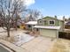 Aerial view of charming two-story home with a two-car garage and landscaped front yard in winter at 3293 S Fairplay St, Aurora, CO 80014