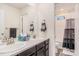 Bathroom featuring double sinks and a view into the adjacent shower area at 26385 E Canal Pl, Aurora, CO 80018