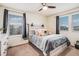 Comfortable bedroom featuring two large windows, modern ceiling fan, and neutral decor at 26385 E Canal Pl, Aurora, CO 80018