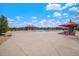 Beautiful community pool area with a pool house, shaded seating, and a clear view of the surrounding neighborhood at 26385 E Canal Pl, Aurora, CO 80018