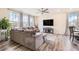 Bright living room with a large sectional, wood floors, ceiling fan, and a wall-mounted tv at 26385 E Canal Pl, Aurora, CO 80018