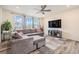 Bright living room with a large sectional, wood floors, ceiling fan, and a wall-mounted tv at 26385 E Canal Pl, Aurora, CO 80018