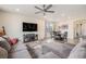 Inviting living room with a large sectional, wood floors, ceiling fan, and a dining table at 26385 E Canal Pl, Aurora, CO 80018