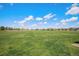 Expansive grassy open field under a bright blue sky with scattered clouds, perfect for recreation and community events at 26385 E Canal Pl, Aurora, CO 80018