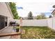 Private backyard with a deck, seating area, well-maintained lawn, and a white fence at 19481 E 50Th Pl, Denver, CO 80249