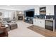 Modern finished basement with a stone fireplace, TV, wet bar, and a sleek beverage refrigerator at 15915 E Summit Fox Ave, Parker, CO 80134