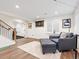 Cozy finished basement area with comfortable seating, natural light, and a stylish ottoman at 15915 E Summit Fox Ave, Parker, CO 80134