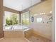 Bathroom featuring a large tub under a window and a separate glass enclosed shower at 15915 E Summit Fox Ave, Parker, CO 80134