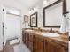 Bathroom with a double sink vanity, wooden cabinets, tile backsplash, and a shower behind the door at 15915 E Summit Fox Ave, Parker, CO 80134