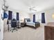 Bedroom with a ceiling fan, desk area, neutral carpet, dark blue curtains, and natural lighting at 15915 E Summit Fox Ave, Parker, CO 80134