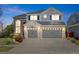 Beautiful two-story home with gray siding, brick accents, three-car garage and manicured landscaping at 15915 E Summit Fox Ave, Parker, CO 80134