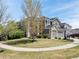 Two-story home with a three-car garage, complemented by stone accents and a well-manicured lawn at 15915 E Summit Fox Ave, Parker, CO 80134