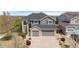 Beautiful two-story home with a three-car garage, complemented by stone accents, lush landscaping, and a well-manicured lawn at 15915 E Summit Fox Ave, Parker, CO 80134