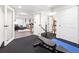 Basement gym area that connects with a living area through glass doors, offering convenience and style at 15915 E Summit Fox Ave, Parker, CO 80134