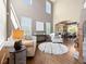 Open living room with tall ceilings, hardwood floors, oversized windows, and views of the dining room at 15915 E Summit Fox Ave, Parker, CO 80134