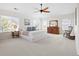 Spacious main bedroom featuring a ceiling fan, bright windows, neutral carpet, and traditional wood furniture at 15915 E Summit Fox Ave, Parker, CO 80134