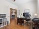Versatile office space with hardwood floors and white trim; kitchen viewable through glass paned french doors at 15915 E Summit Fox Ave, Parker, CO 80134