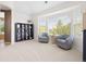 Bright sitting area with neutral paint and carpet, large windows, and comfortable swivel chairs at 15915 E Summit Fox Ave, Parker, CO 80134