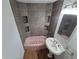 Upgraded bathroom features tiled shower with shelves, pink tub, and pedestal sink at 1078 Elmira St, Aurora, CO 80010