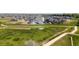 Aerial view of the real estate showcasing a vibrant green field and a walking path through the neighborhood at 2141 Fountain Cir, Erie, CO 80516