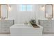 Luxurious bathroom with a soaking tub, dual vanities, and elegant gold fixtures at 2141 Fountain Cir, Erie, CO 80516