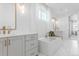 Bright bathroom featuring a soaking tub, separate vanities, and upscale finishes at 2141 Fountain Cir, Erie, CO 80516