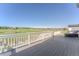 Spacious deck with white railing overlooking a sprawling green field and mountain range at 2141 Fountain Cir, Erie, CO 80516