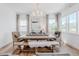 Bright dining room featuring a wooden table with bench seating, stylish decor, and abundant natural light from large windows at 2141 Fountain Cir, Erie, CO 80516