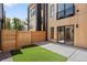 Modern home's backyard with a wooden fence, small grass area, concrete patio, and a sliding glass door entrance at 1262 N Stuart St # 2, Denver, CO 80204