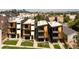 Modern townhomes feature balconies and a landscaped yard, complemented by a backdrop of the city skyline at 1262 N Stuart St # 2, Denver, CO 80204