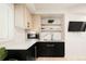 Contemporary wet bar features light wood and black cabinetry, marble backsplash at 1262 N Stuart St # 2, Denver, CO 80204