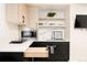 Beautiful wet bar with light wood and black cabinets and marble backsplash at 1262 N Stuart St # 2, Denver, CO 80204