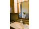 Bathroom sink and mirror, complemented by wooden cabinets at 933 Skeel St, Brighton, CO 80601