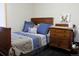 Cozy bedroom features a wooden bed frame with blue bedding and matching wooden dresser at 933 Skeel St, Brighton, CO 80601