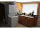 Efficient kitchen with compact washer/dryer unit and ample cabinet space at 933 Skeel St, Brighton, CO 80601