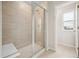 A well-lit bathroom featuring a tiled walk-in shower with glass door at 16633 W 93Rd Way, Arvada, CO 80007