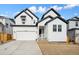Charming two-story home with white siding, black trim, and well-manicured lawn on a sunny day at 16633 W 93Rd Way, Arvada, CO 80007