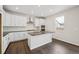 A modern kitchen featuring white cabinets, a kitchen island, and stainless steel appliances at 16633 W 93Rd Way, Arvada, CO 80007