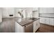 Kitchen with a large island featuring an undermount sink, stainless steel appliances, and hardwood floors at 16633 W 93Rd Way, Arvada, CO 80007