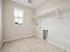 Tiled laundry room featuring a window for natural light and built-in shelving for all of your storage needs at 16633 W 93Rd Way, Arvada, CO 80007
