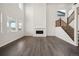 Living room showcasing tall windows, modern floors, a fireplace, and a staircase at 16633 W 93Rd Way, Arvada, CO 80007