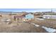 Distant aerial view of a two-story home on expansive land with a mountain range backdrop at 12990 Mesa View Rd, Larkspur, CO 80118