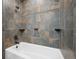 Stylish bathroom with modern tiling and a white tub, creating a spa-like experience at 12990 Mesa View Rd, Larkspur, CO 80118