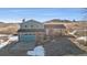 Charming two-story home in a rural setting, featuring a blue garage door and brick accents at 12990 Mesa View Rd, Larkspur, CO 80118
