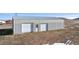 Large detached garage with dual garage doors, offering ample space for vehicles and storage at 12990 Mesa View Rd, Larkspur, CO 80118