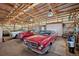 Interior view of a large garage or barn with multiple cars and ample storage space at 12990 Mesa View Rd, Larkspur, CO 80118