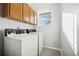 Practical laundry room features a window and ample cabinet space at 12990 Mesa View Rd, Larkspur, CO 80118