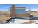 Side exterior view of the two-story home featuring a brick chimney at 12990 Mesa View Rd, Larkspur, CO 80118