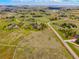 An aerial image showcasing a spacious countryside with multiple homes, wide open fields and tree lined streets at 34682 Stampede Cir, Elizabeth, CO 80107